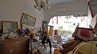 A woman sits among the rubble in her damaged house in the Lebanese capital Beirut on August 6, 2020, after a massive explosion shook the city