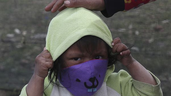 Ekvador'da maske takan bir çocuk Ekvador'da maske takan bir çocuk