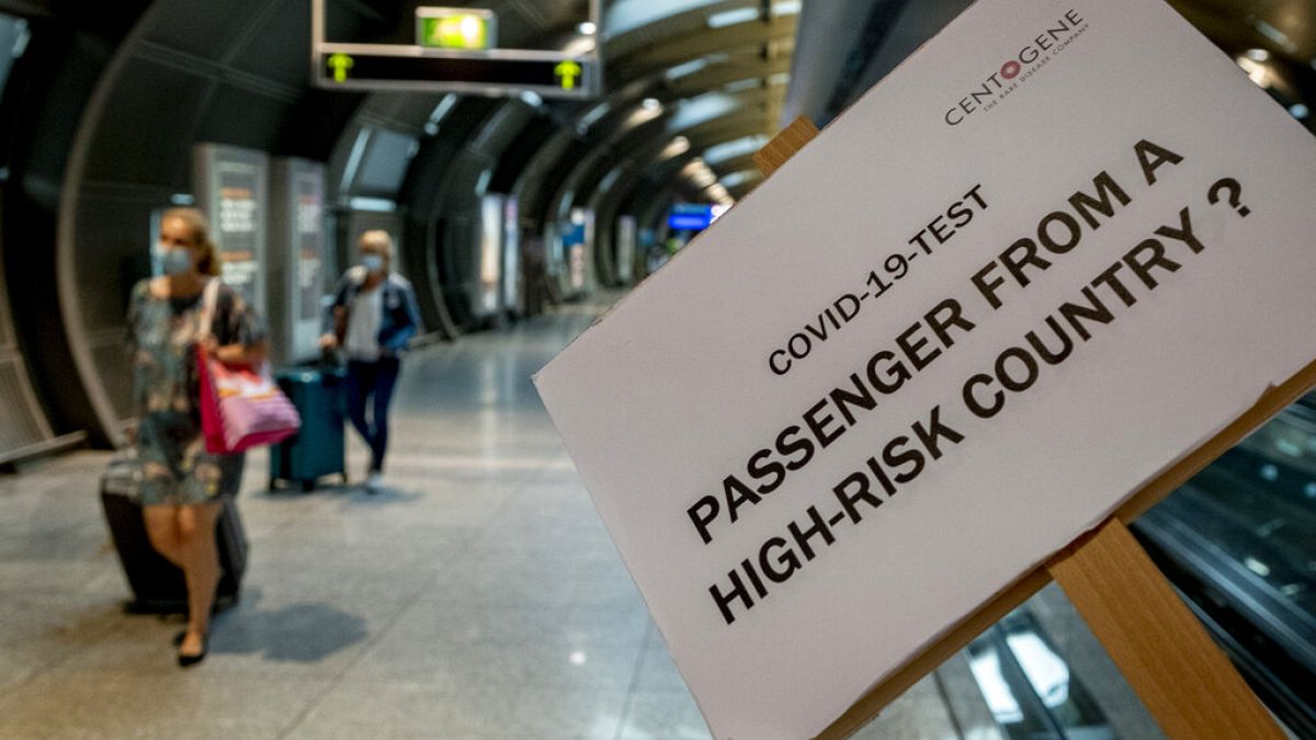 A sign helps passengers to find the COVID-19 test center at the airport in Frankfurt, Germany, Saturday, Aug. 8, 2020