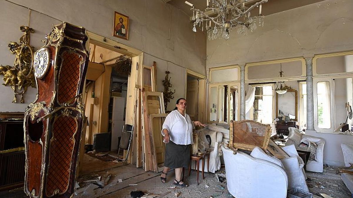 Egy bejrúti asszony mutatja a robbanásban romossá vált otthonát