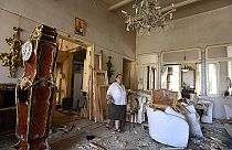 Egy bejrúti asszony mutatja a robbanásban romossá vált otthonát