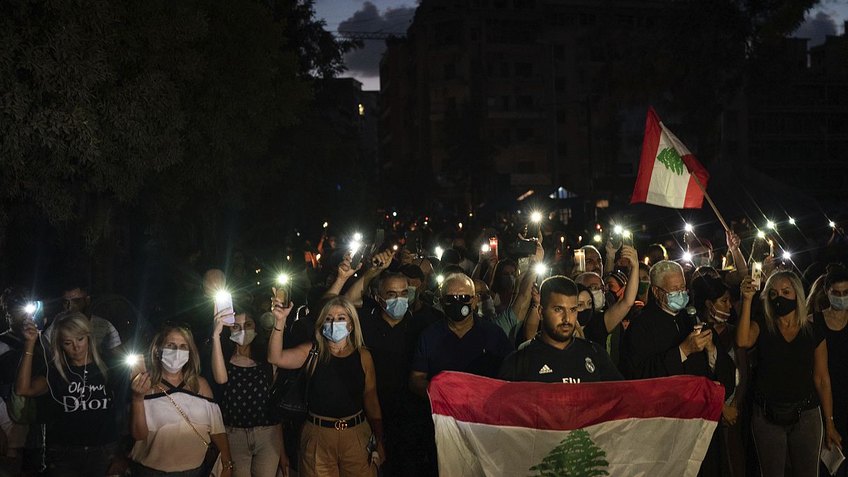 Demonstrators march holding candles and flashlights honoring the victims of the deadly explosion at Beirut port which devastated large parts of the capital, in Beirut, Lebanon