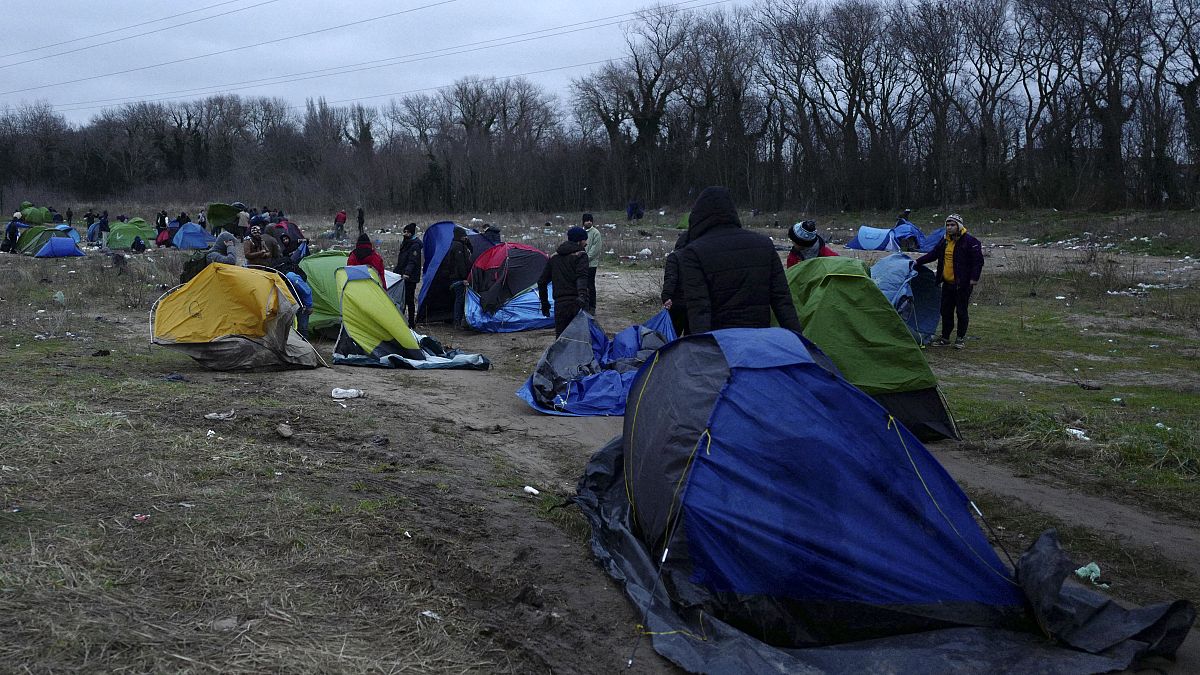 مهاجرون يحزمون أمتعتهم في مخيم مؤقت في كاليه ، شمال فرنسا