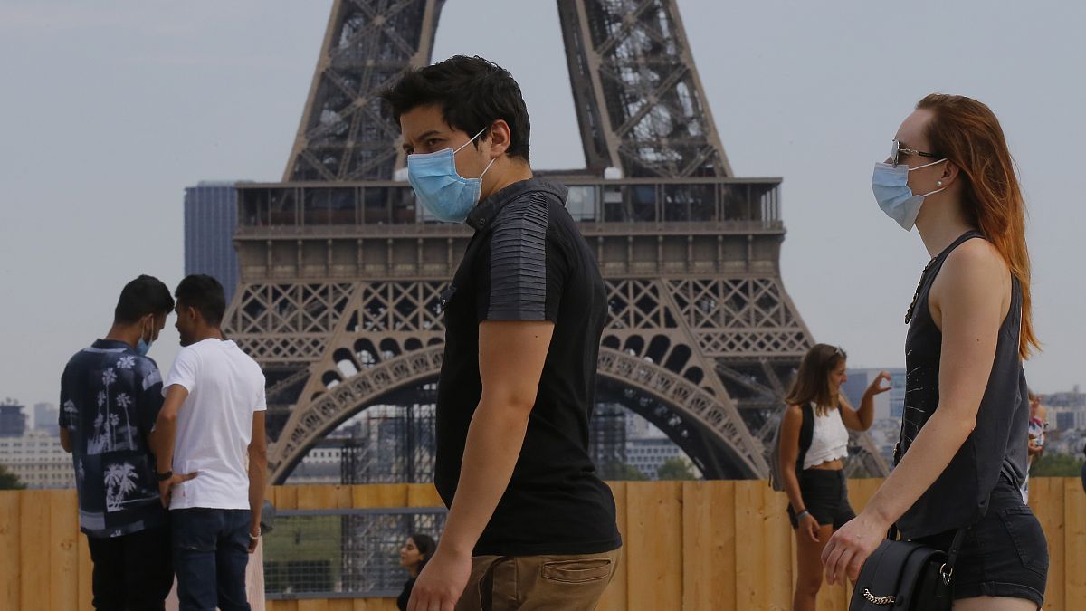 People wearing masks to prevent the spread of COVID-19 walk at Trocadero plaza near Eiffel Tower in Paris, Saturday, Aug 8, 2020.
