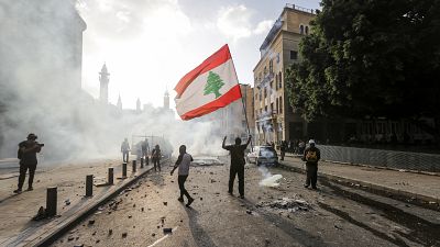 A Lebanese protester waves the national flag during clashes with security forces in downtown Beirut on August 8, 2020.