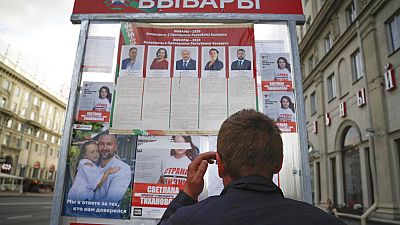 Mann vor Wahlkampfplakaten in Minsk