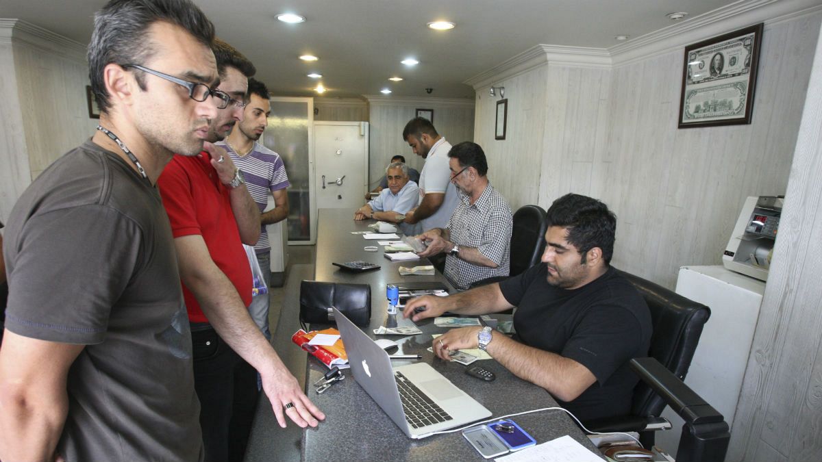 Iranians exchange currencies in a money exchange bureau, in downtown Tehran, Iran
