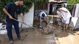 Un grupo de vecinos limpian los bajos de su casa en la isla de Eúbea (Grecia)
