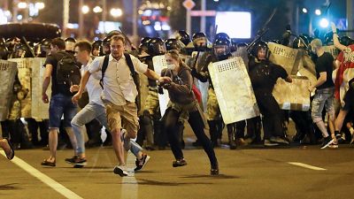 Tüntetők szaladnak a rendőrök elől Minszkben 2020. augusztus 9-én éjjel