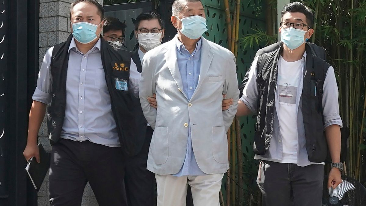 Hong Kong media tycoon Jimmy Lai, center, who founded local newspaper Apple Daily, is arrested by police officers at his home in Hong Kong, Monday, Aug. 10, 2020. 