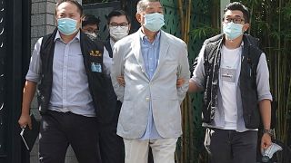 Hong Kong media tycoon Jimmy Lai, center, who founded local newspaper Apple Daily, is arrested by police officers at his home in Hong Kong, Monday, Aug. 10, 2020. 