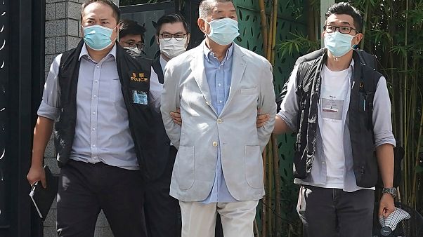 Hong Kong media tycoon Jimmy Lai, center, who founded local newspaper Apple Daily, is arrested by police officers at his home in Hong Kong, Monday, Aug. 10, 2020. Hong Kong media tycoon Jimmy Lai, center, who founded local newspaper Apple Daily, is arrested by police officers at his home in Hong Kong, Monday, Aug. 10, 2020.