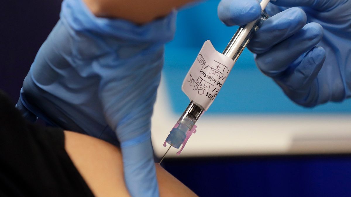 Volunteer Yash is injected with the vaccine as part of an Imperial College vaccine trial, at a clinic in London, Aug. 5, 2020. 