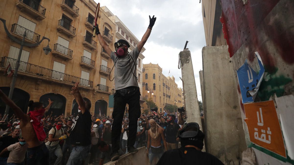 Tüntetők ünnepelnek Bejrútban, miután sikerült lebonatniuk egy betonakadályt, ami a parlamenthez vezető utat zárta le 