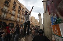 Tüntetők ünnepelnek Bejrútban, miután sikerült lebonatniuk egy betonakadályt, ami a parlamenthez vezető utat zárta le