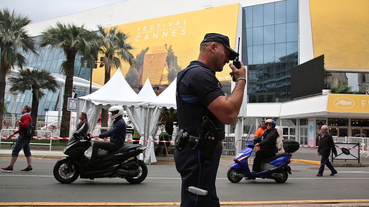 FILE - A police officer patrols in front of the entrance of the Festival Palace in Cannes, May 2016.