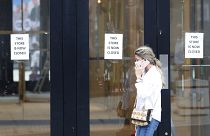 A woman walks by a closed store, in London, Thursday, July 16, 2020. Figures show UK employment suffered the biggest three-month decline since the 2009 recession.