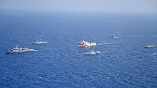 Le navire turc de recherches gazières, Oruc Reis, en rouge et blance, entouré de navires de la marine turque, en Méditerranée orientale.