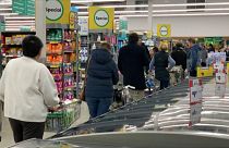 People queuing inside supermarket, waiting to checkout