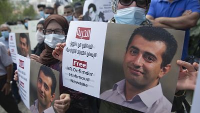 متظاهرون يحملون لافتات لإطلاق سراح محمود نواجعة في رام الله، الضفة الغربية. 
