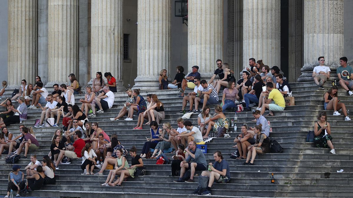 Almanya'nın Münih kentinde gün batımında Glyptothek Müzesi önünde oturan vatandaşlar