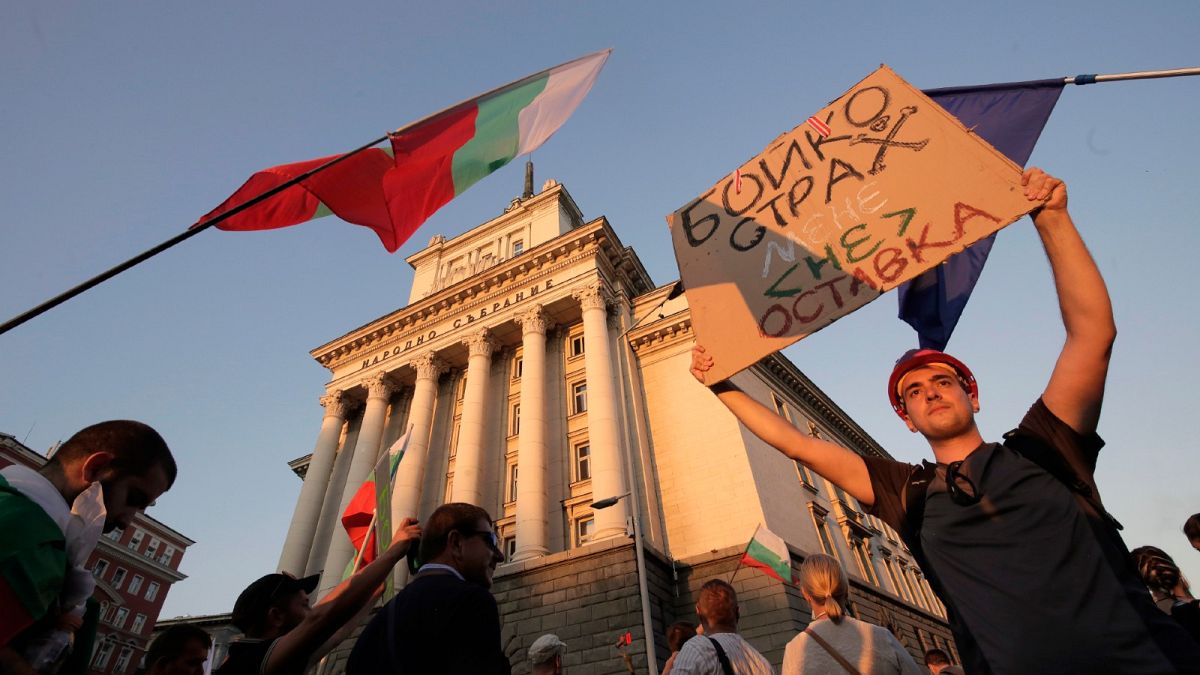 Protesters carry a poster reading "Borissov, I am not afraid, but you are! Resignation" (in Bulgarian) during a mass protest in downtown Sofia, Bulgaria, on July 29.