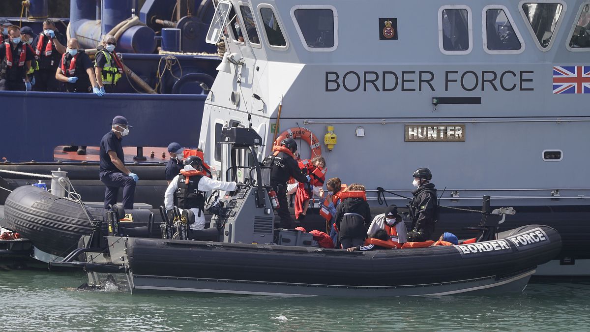 A UK Border Force vessel brings a group of people thought to be migrants into the port city of Dover, England, from small boats, Saturday Aug. 8, 2020. 