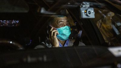 Hong Kong pro-democracy media mogul Jimmy Lai speaks on the phone after being released on bail from the Mong Kok police station.