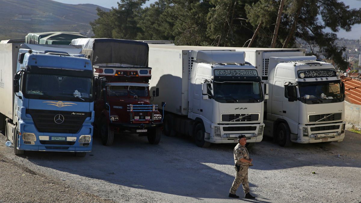 In this Oct. 31, 2018 photo, a Lebanese customs officer walks past trucks waiting to cross into Syria from the Lebanese border crossing point of al-Masnaa