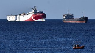 In this photograph taken from the Mediterranean shores near the city of Antalya, Turkey, a merchant ship, top right, sails past the research vessel Oruc Rei