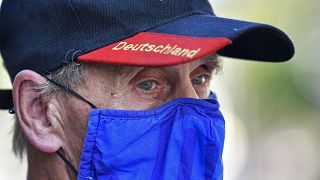 A man wears a face mask in the colours of the German first division soccer team FC Schalke 04. Gelsenkirchen, Germany, Wednesday, Aug. 12, 2020.