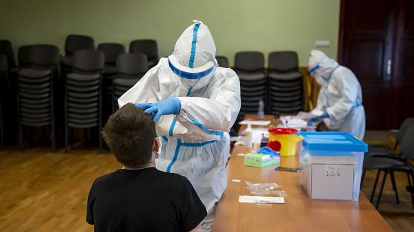 Mintát vesznek egy fiú garatnyálkahártyájáról koronavírusteszthez a Debreceni Egyetem mintavételi pontján 2020. május 14-én Mintát vesznek egy fiú garatnyálkahártyájáról koronavírusteszthez a Debreceni Egyetem mintavételi pontján 2020. május 14-én
