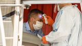 A driver has his body temperature measured before taking a voluntary Covid-19 blood test, in Rome, Wednesday, July 29, 2020.