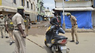 شرطي يضرب سائق دراجة لانتهاكه أوامر منع التجمهر بعد يوم من احتجاجات عنيفة في بنغالورو ، الهند