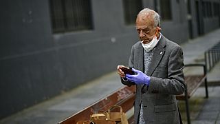 Un hombre fuma quitándose la mascarilla en España