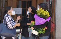 Women outside a funeral home where the body of Benoît Maria was brought