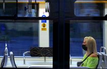 Védőmaszkot viselő és a javasolt távolságtartással elhelyezkedő fiatal utas a Budapesti Közlekedési Központ egyik villamosán
