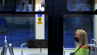 Védőmaszkot viselő és a javasolt távolságtartással elhelyezkedő fiatal utas a Budapesti Közlekedési Központ egyik villamosán