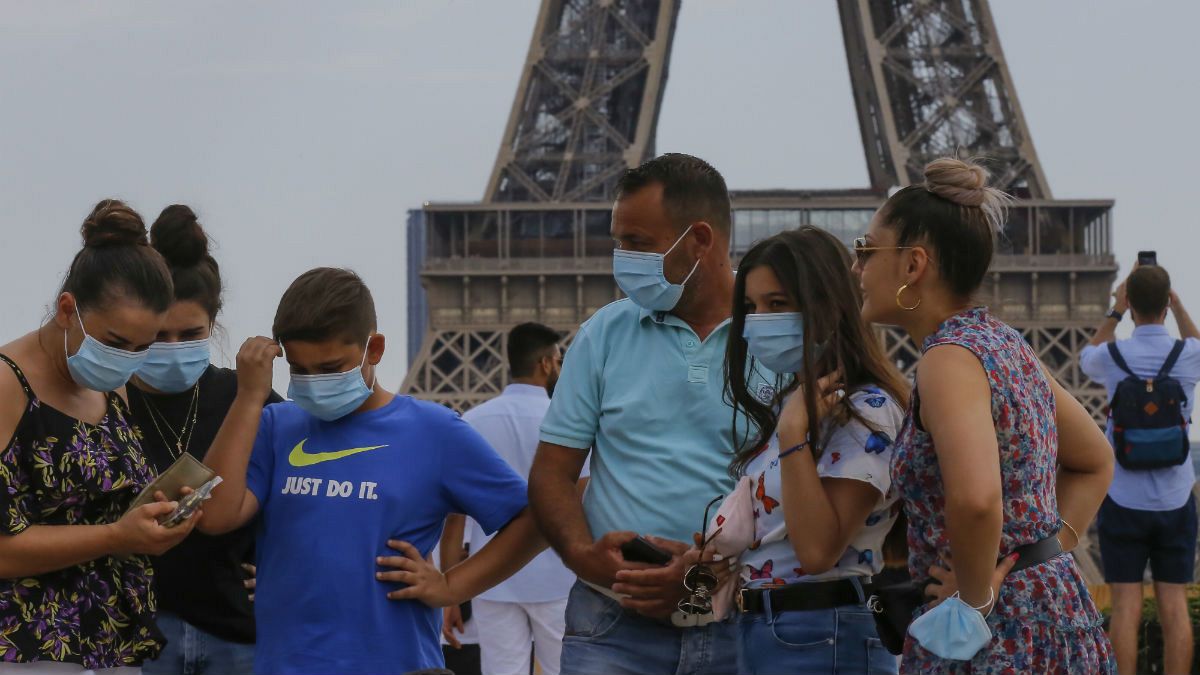 A Italian tourist family wearing a masks to prevent the spread of COVID-19 gather at Trocadero plaza near Eiffel Tower in Paris