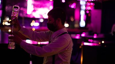 A waiter wearing a face mask to prevent the spread of coronavirus works in a discotheque in Madrid, Spain, early Saturday, July 25, 2020