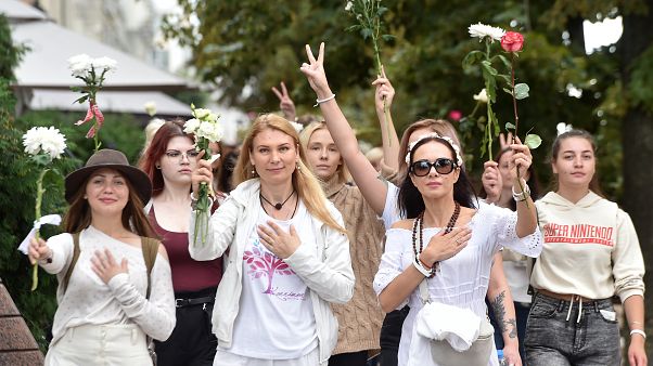 Un gruppo di donne con in mano dei fiori manifesta contro la brutale repressione della polizia a Minsk, 13 agosto Un gruppo di donne con in mano dei fiori manifesta contro la brutale repressione della polizia a Minsk, 13 agosto