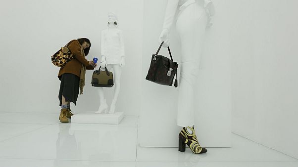 A visitor takes photo of a bag at an exhibition by french luxury brand Louis Vutton in Beijing A visitor takes photo of a bag at an exhibition by french luxury brand Louis Vutton in Beijing