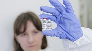 نمونه‌ای از واکسن روسی کووید-۱۹ در دستان محقق روسی