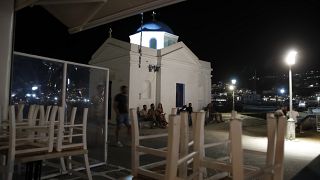 Mykonos: il ristorante ha chiuso a mezzanotte, ma i turisti si "assembrano" davanti alla chiesa ortodossa.