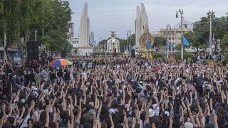 Pro-democracy students raise three-fingers, symbol of resistance salute, during a rally in Bangkok, Thailand.