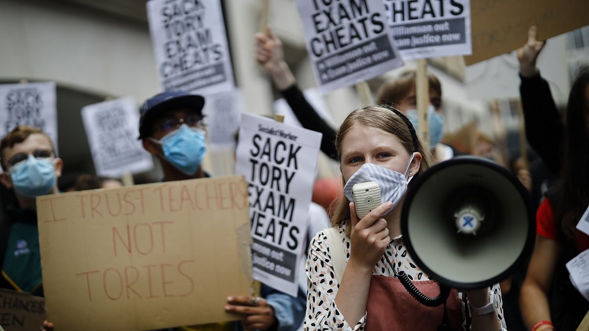 Students hold placards as they protest outside the Department for Education in central London on August 14, 2020.