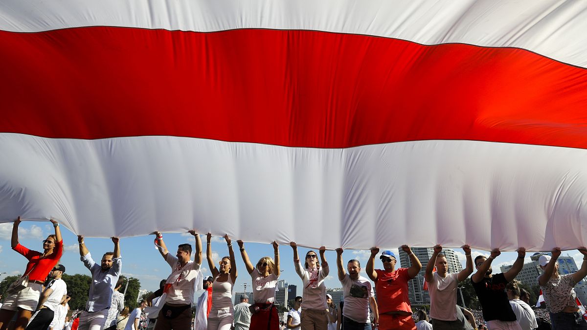 Opositores hacen ondear una bandera en Minsk, Bielorrusia