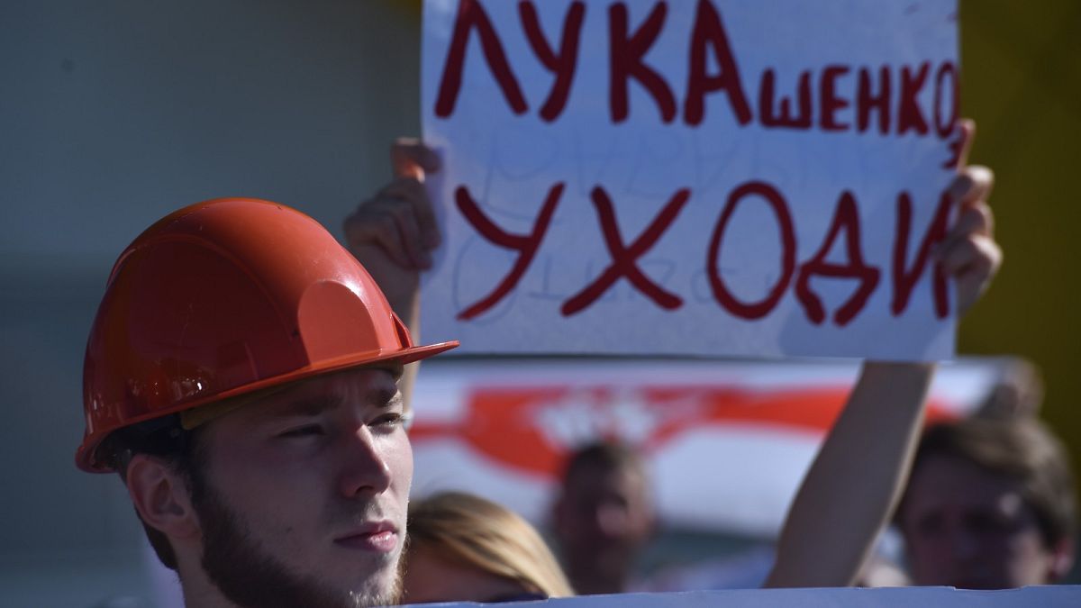 Workers of Minskenergo (Minsk Energy Company) hold a poster reading "Lukashenko go away!" during the rally in Minsk, on August 17, 2020,