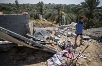طفل فلسطيني يقف على أنقاض بيته المهدم بسبب القصف الإسرائيلي