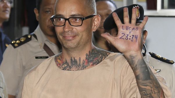 Artur Segarra Princep de España levanta la mano mostrando un popular verso de la Biblia en la palma de la misma leyendo, "Lucas 23:34" al llegar al tribunal penal de Bangkok, Artur Segarra Princep de España levanta la mano mostrando un popular verso de la Biblia en la palma de la misma leyendo, "Lucas 23:34" al llegar al tribunal penal de Bangkok,